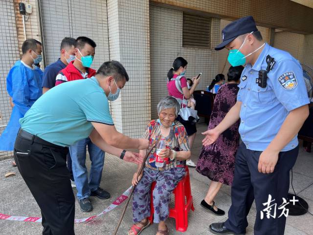 連州市委常委、副市長(zhǎng)、九陂鎮(zhèn)黨委書記綦鴻偉在核酸檢測(cè)現(xiàn)場(chǎng)協(xié)助老人參加核酸檢測(cè)，為老人做好防暑措施。